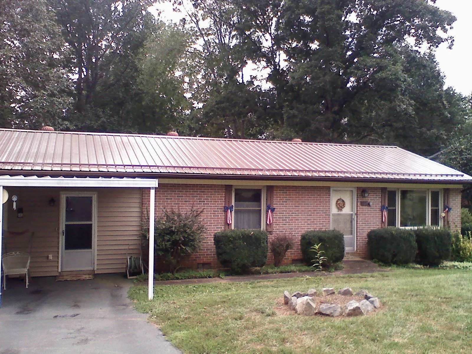 Bronze metal roof and carport on a brick ranch home — Roof Repair work by our crew in Landis